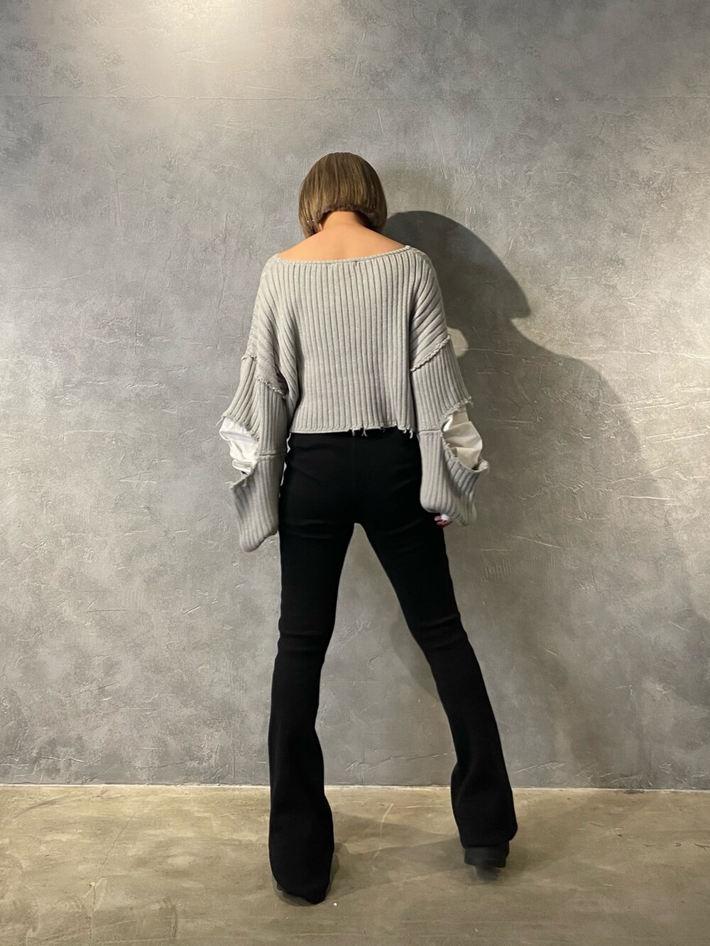 グレー系のニット/セーター、ブラック系のブーツ、ブラック系のその他パンツを着用したレディースの冬コーディネートの3枚目の写真