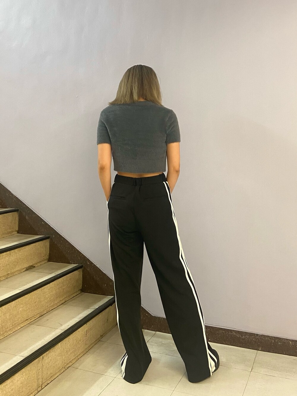 グレー系のニット/セーター、ブラック系のその他パンツ、ブラック系のブーツを着用したレディースの夏コーディネートの4枚目の写真