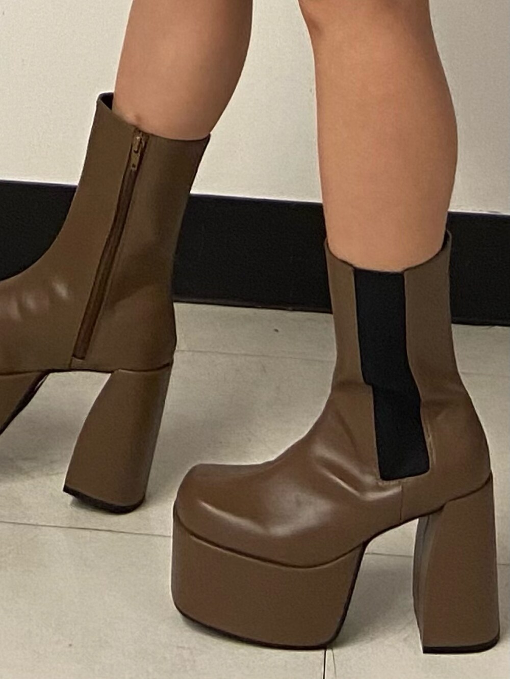 ブラック系のニット/セーター、ブラウン系のブーツ、ブラック系のスカートを着用したレディースの冬コーディネートの8枚目の写真