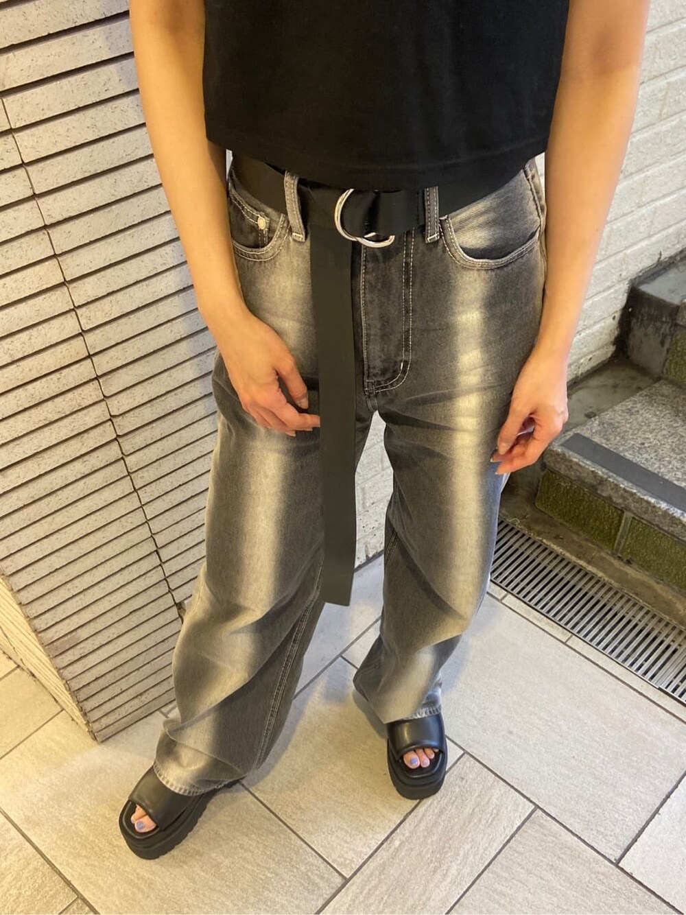 ブラック系のサンダル、ブラック系のデニムパンツ、ブラック系のTシャツ/カットソーを着用したレディースの春コーディネートの6枚目の写真