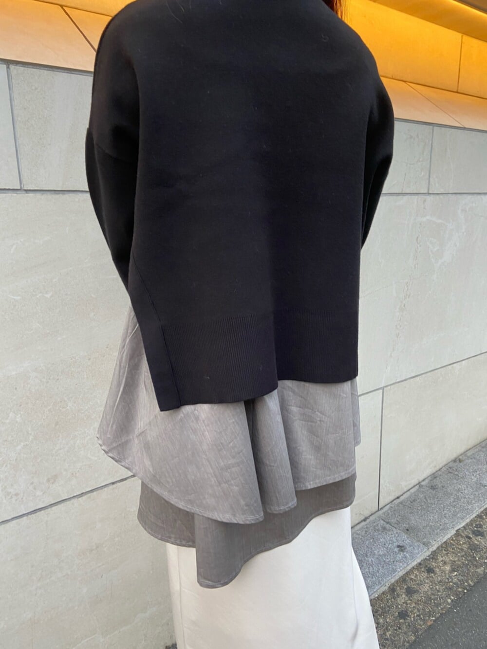 ブラック系のサンダル、ブラック系のニット/セーター、ホワイト系のスカートを着用したレディースの秋コーディネートの4枚目の写真