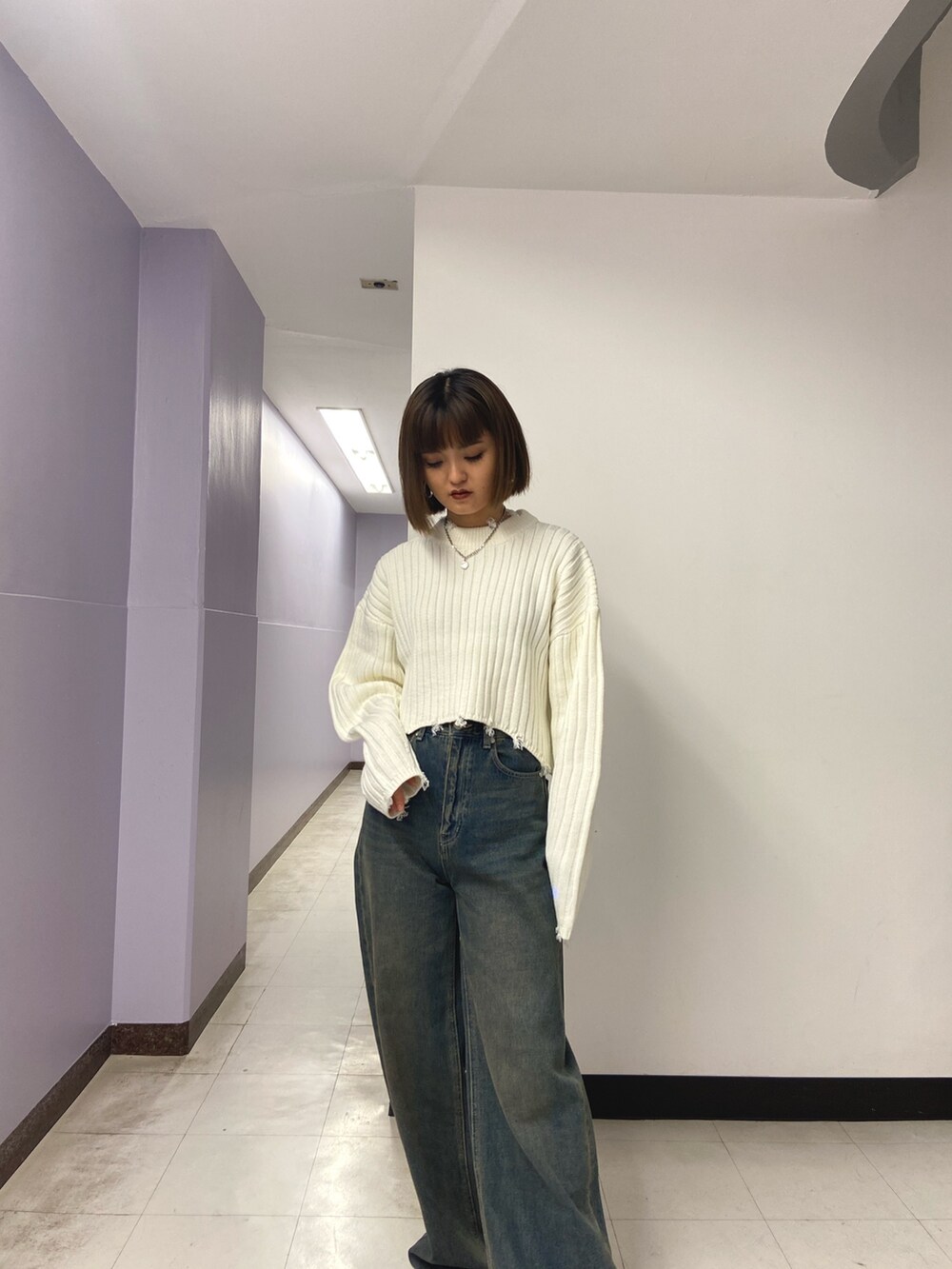ホワイト系のニット/セーター、ブルー系のデニムパンツ、ブラック系のブーツを着用したレディースの秋コーディネートの6枚目の写真