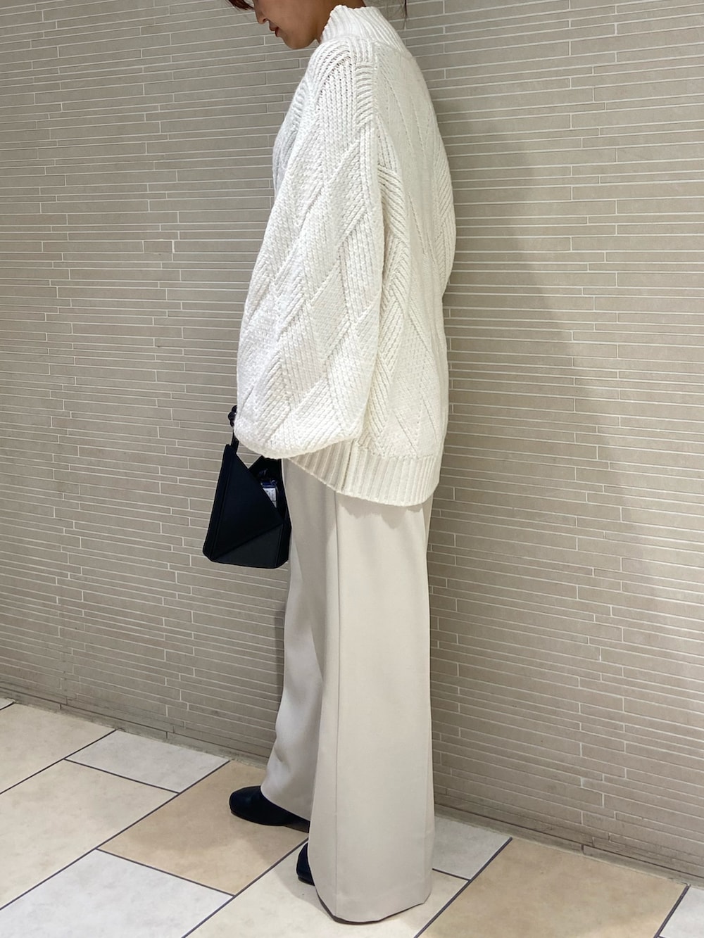 ホワイト系のニット/セーター、ホワイト系のその他パンツ、ブラック系のブーツを着用したレディースの秋コーディネートの3枚目の写真