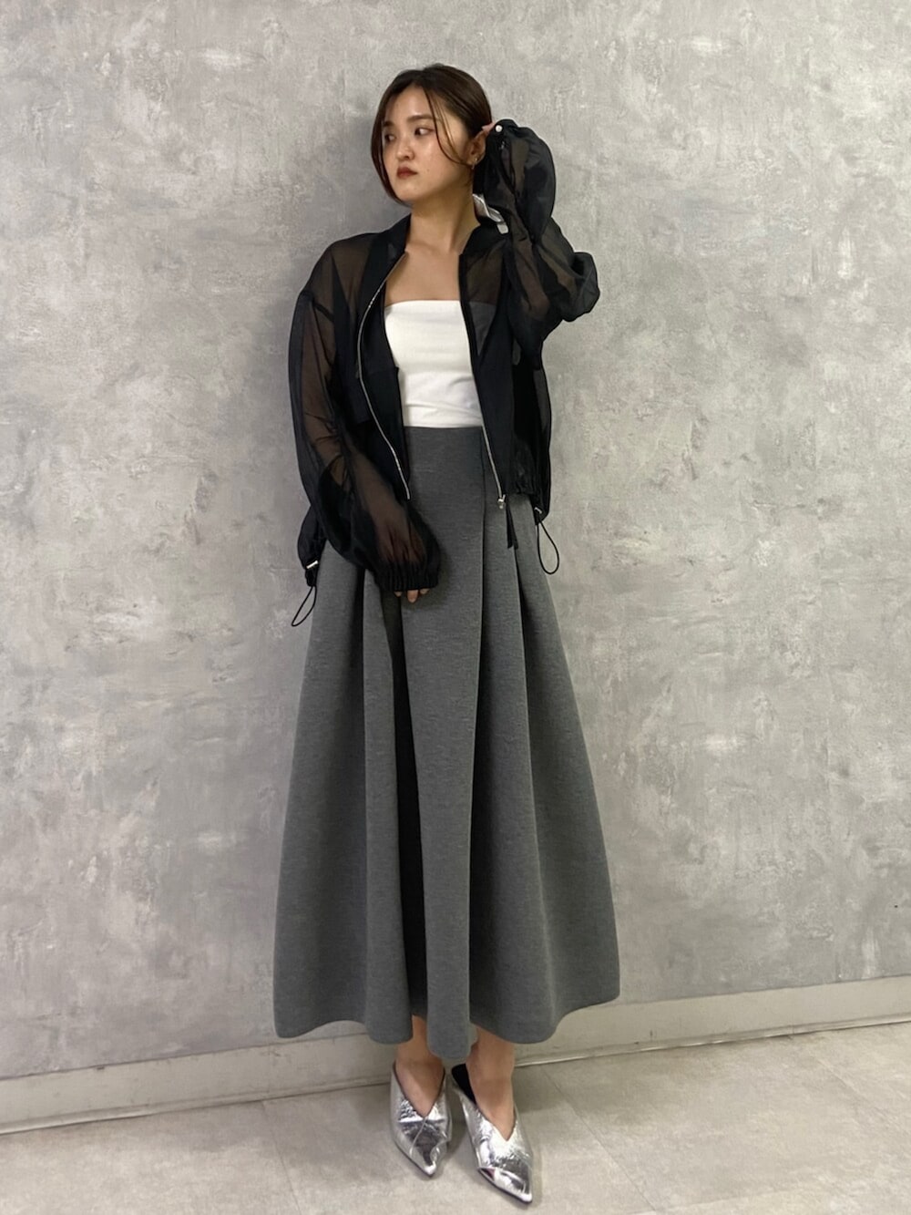 シルバー系のパンプス、ホワイト系のキャミソール、ブラック系のブルゾンを着用したレディースの春コーディネートの2枚目の写真