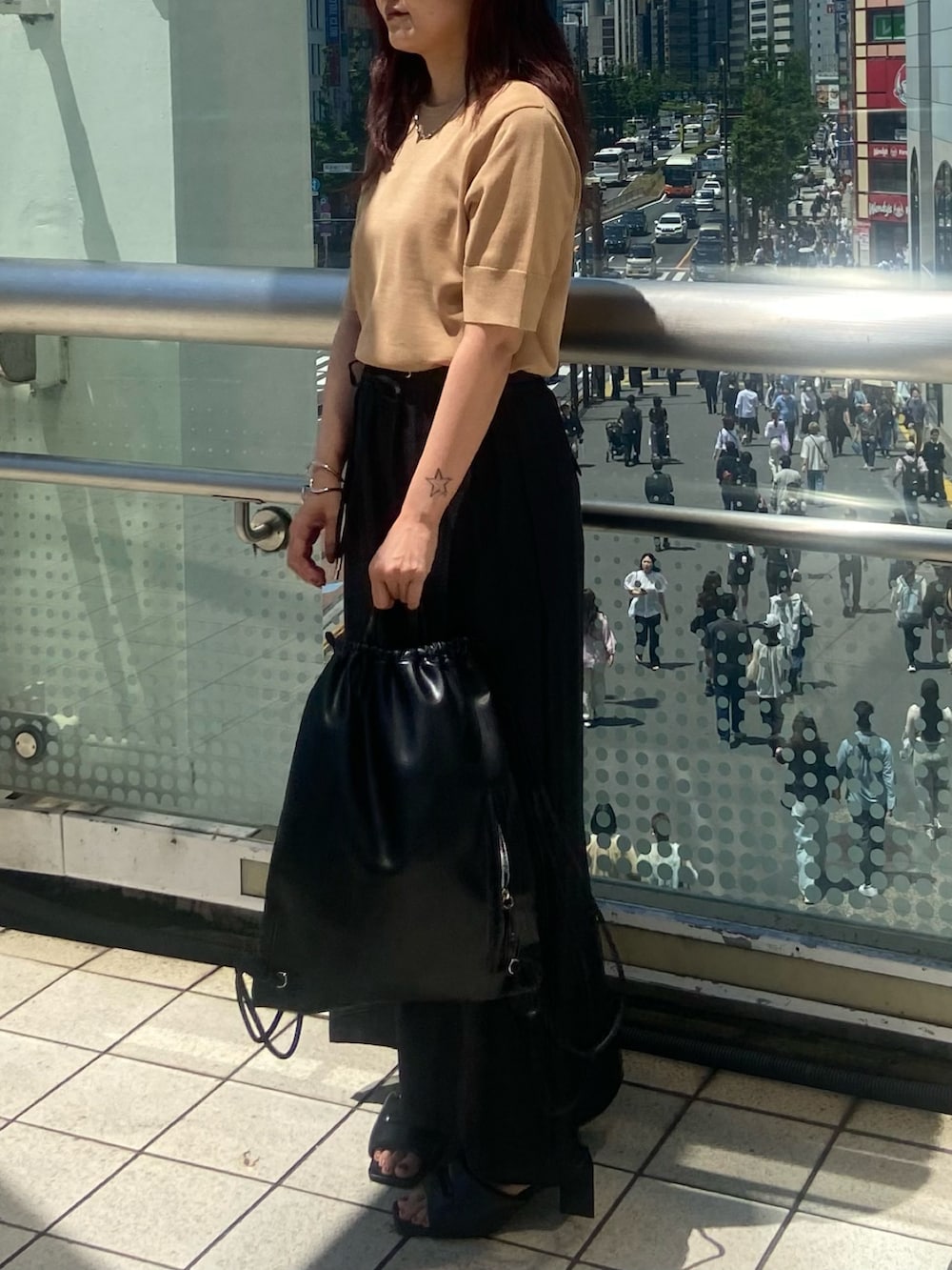 ブラック系のスカート、ブラック系のサンダル、ベージュ系のニット/セーターを着用したレディースの夏コーディネートの3枚目の写真