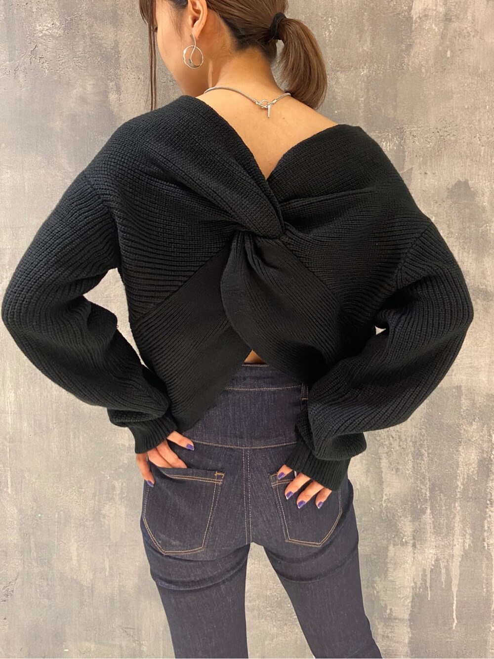 ブラック系のローファー、ブルー系のデニムパンツ、ブラック系のニット/セーターを着用したレディースの秋コーディネートの4枚目の写真