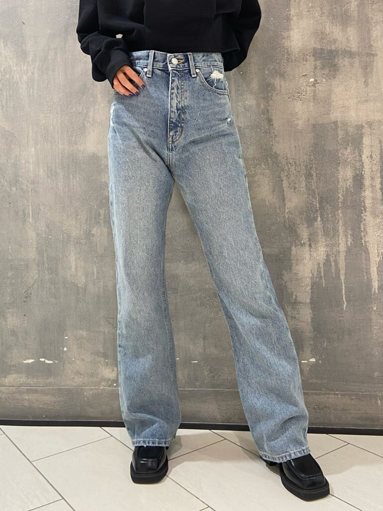 ブラック系のブーツ、ブラック系のTシャツ/カットソー、ブルー系のデニムパンツを着用したレディースの秋コーディネートの5枚目の写真