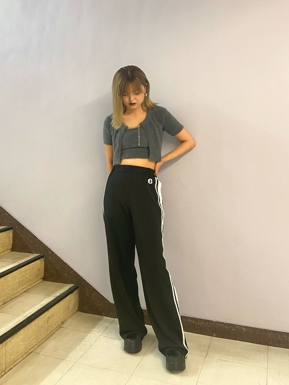 グレー系のニット/セーター、ブラック系のその他パンツ、ブラック系のブーツを着用したレディースの夏コーディネートの2枚目の写真