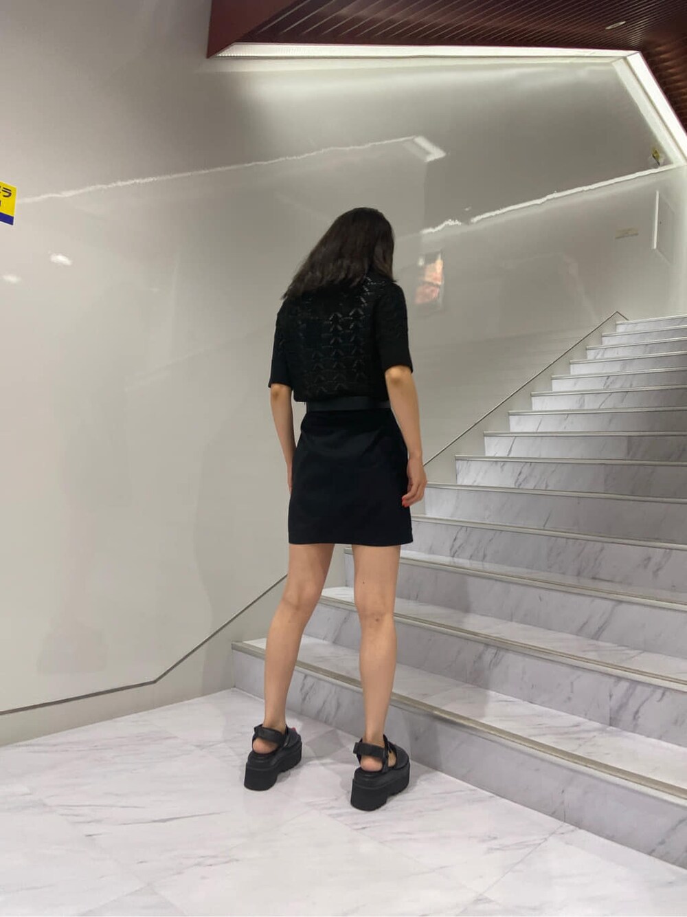 ブラック系のサンダル、ブラック系のニット/セーター、ブラック系のスカートを着用したレディースの夏コーディネートの4枚目の写真