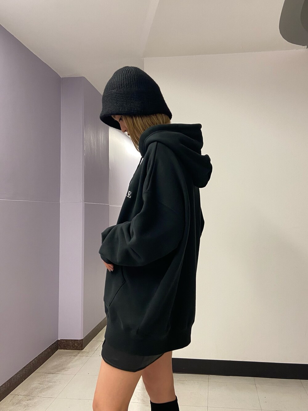 ブラック系のパーカー、その他のスカート、ブラック系のブーツを着用したレディースの秋コーディネートの7枚目の写真