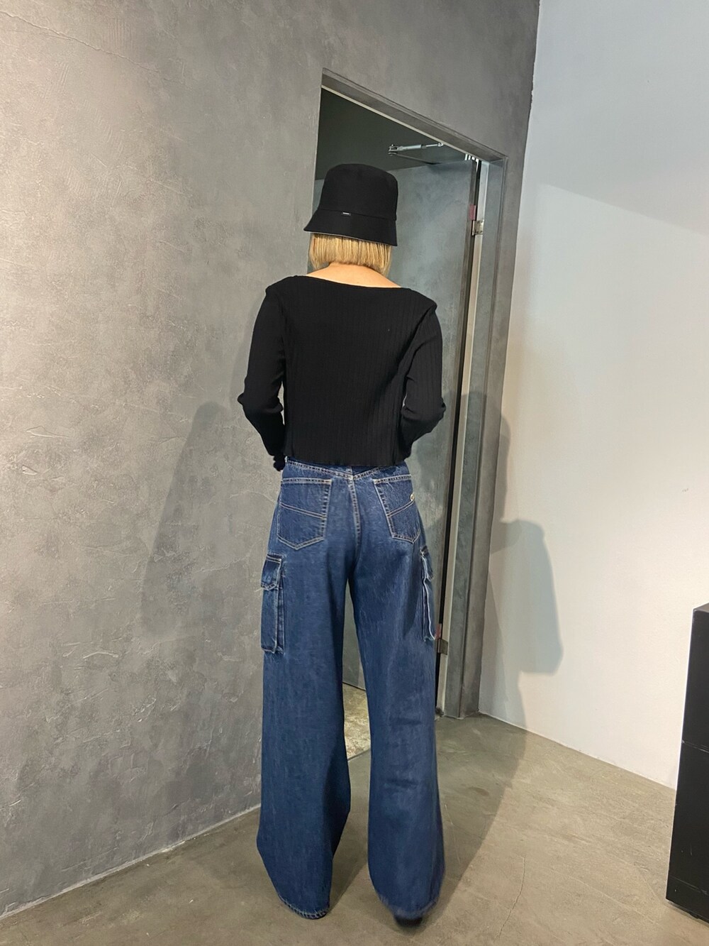 ブラック系のTシャツ/カットソー、ブルー系のデニムパンツ、ブラック系のサンダルを着用したレディースの冬コーディネートの3枚目の写真