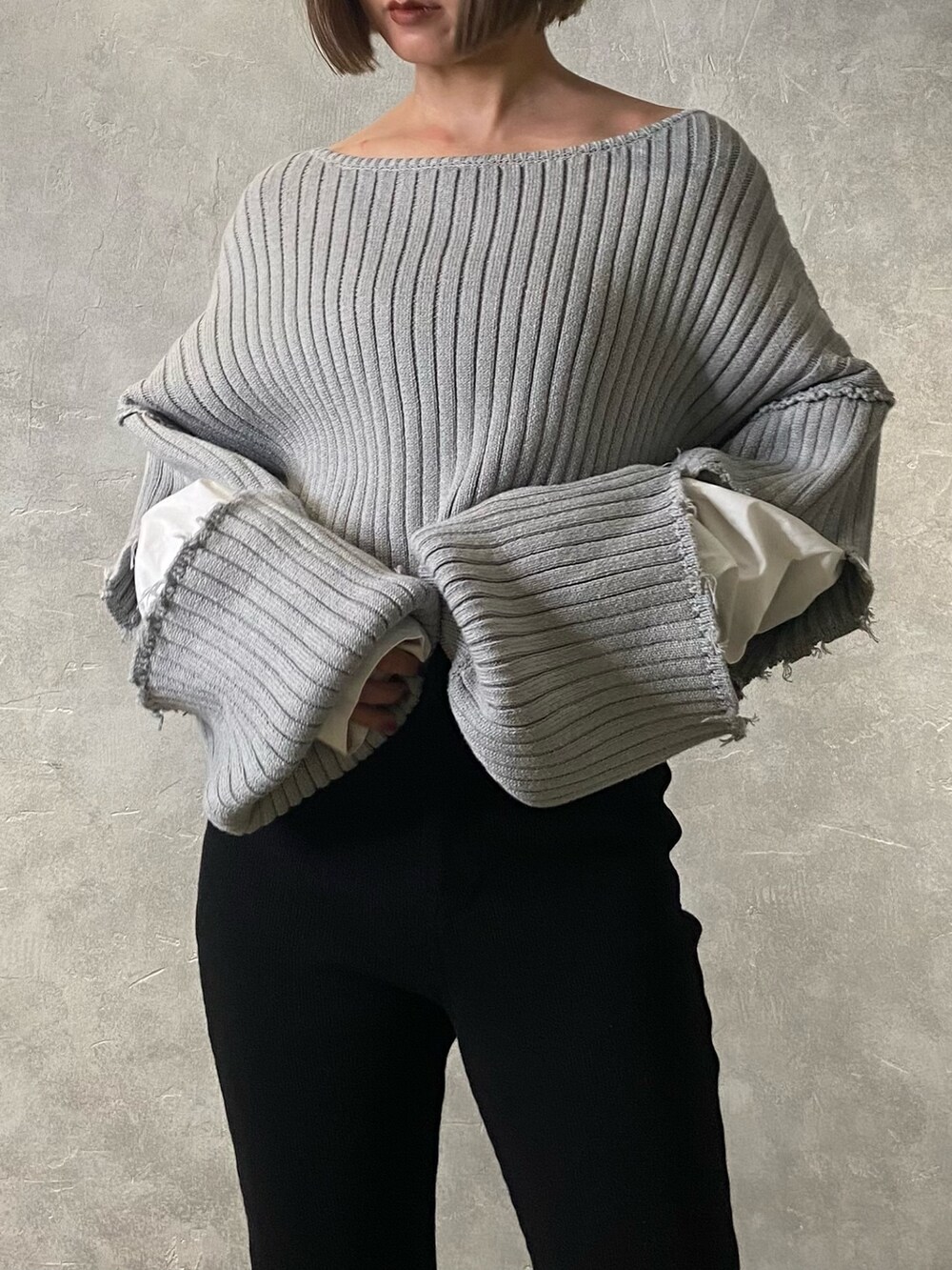 グレー系のニット/セーター、ブラック系のブーツ、ブラック系のその他パンツを着用したレディースの冬コーディネートの6枚目の写真