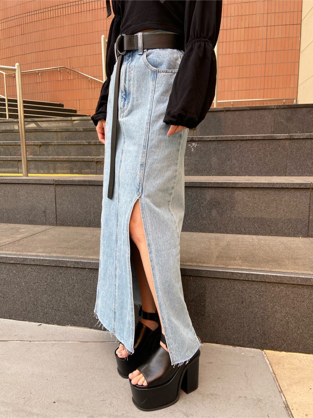 ブルー系のスカート、ブラック系のTシャツ/カットソー、ブラック系のサンダルを着用したレディースの春コーディネートの6枚目の写真