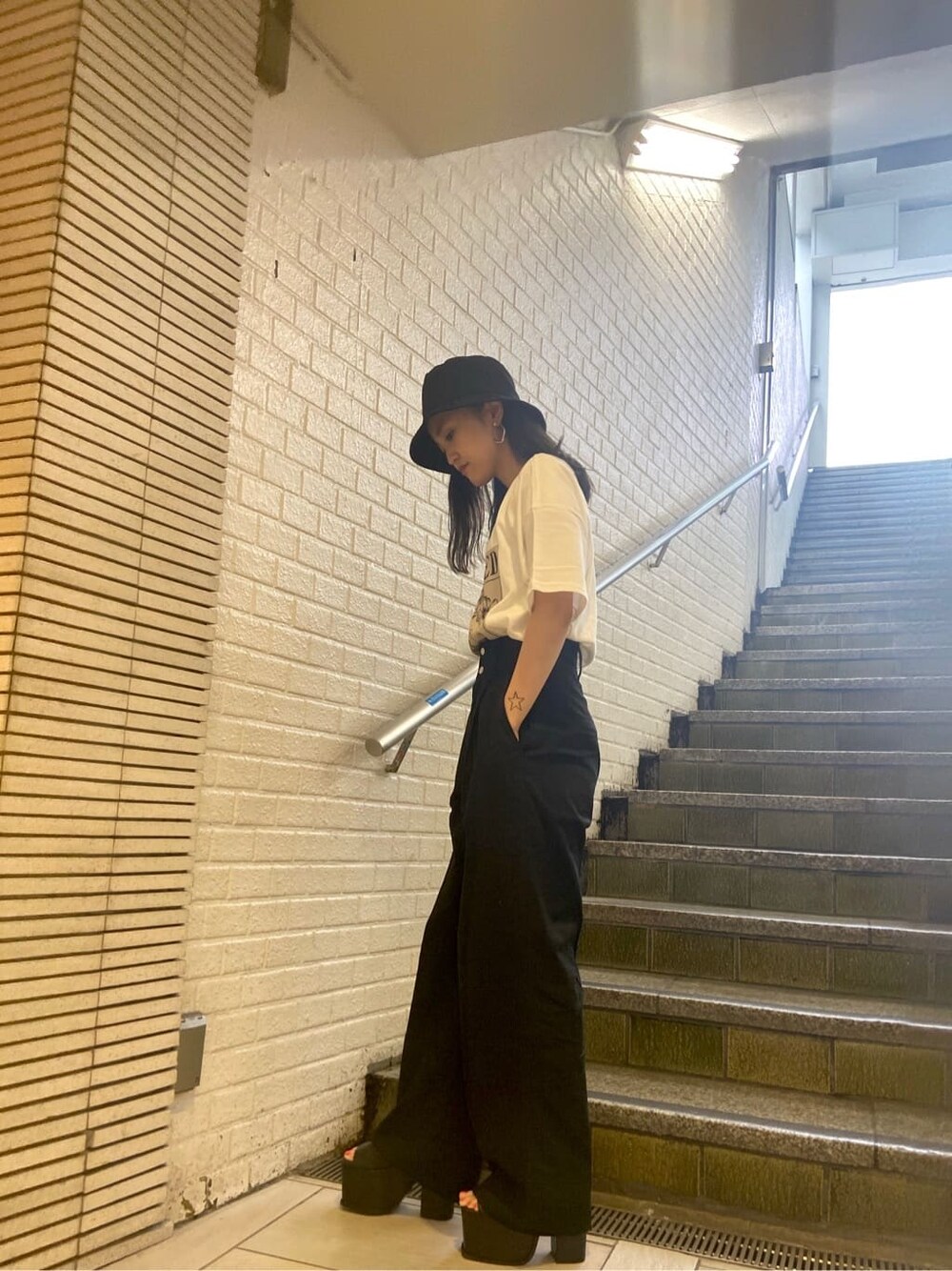 ブラック系のサンダル、ブラック系のその他パンツ、ホワイト系のTシャツ/カットソーを着用したレディースの夏コーディネートの3枚目の写真