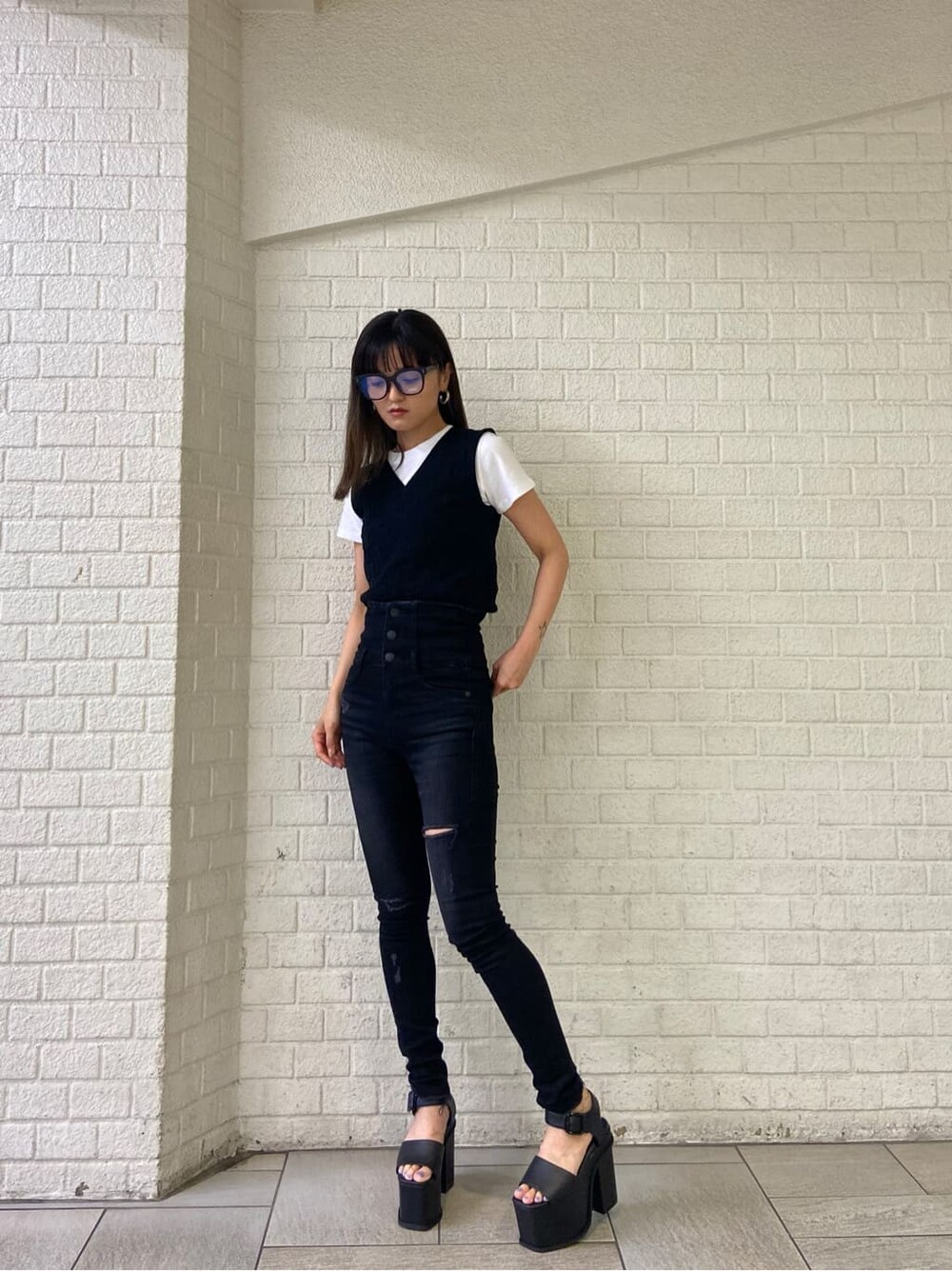 ブラック系のサンダル、ブラック系のタンクトップ、ホワイト系のTシャツ/カットソーを着用したレディースの春コーディネートの2枚目の写真