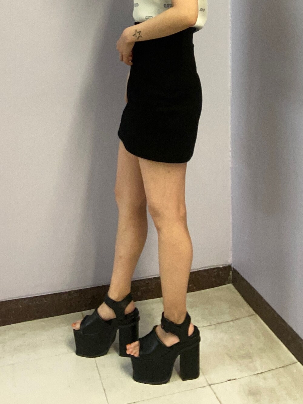 ホワイト系のニット/セーター、ブラック系のスカート、ブラック系のサンダルを着用したレディースの春コーディネートの6枚目の写真