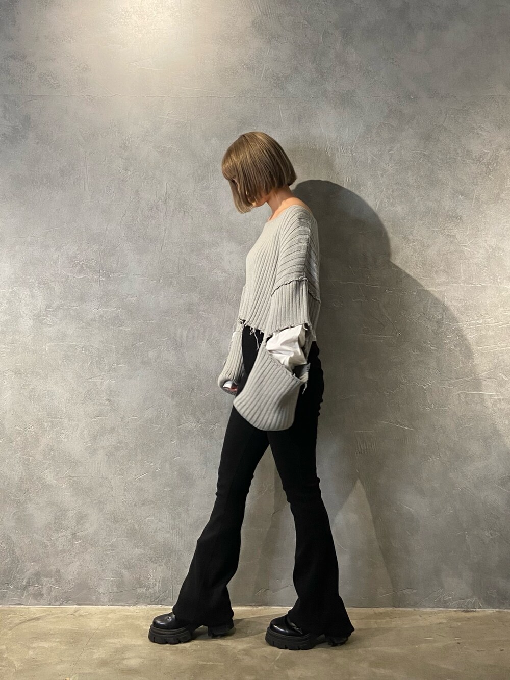 グレー系のニット/セーター、ブラック系のブーツ、ブラック系のその他パンツを着用したレディースの冬コーディネートの2枚目の写真