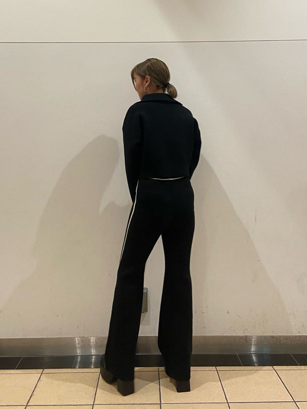 ブラック系のニット/セーター、ブラック系のその他パンツ、ブラック系のブーツを着用したレディースの秋コーディネートの3枚目の写真