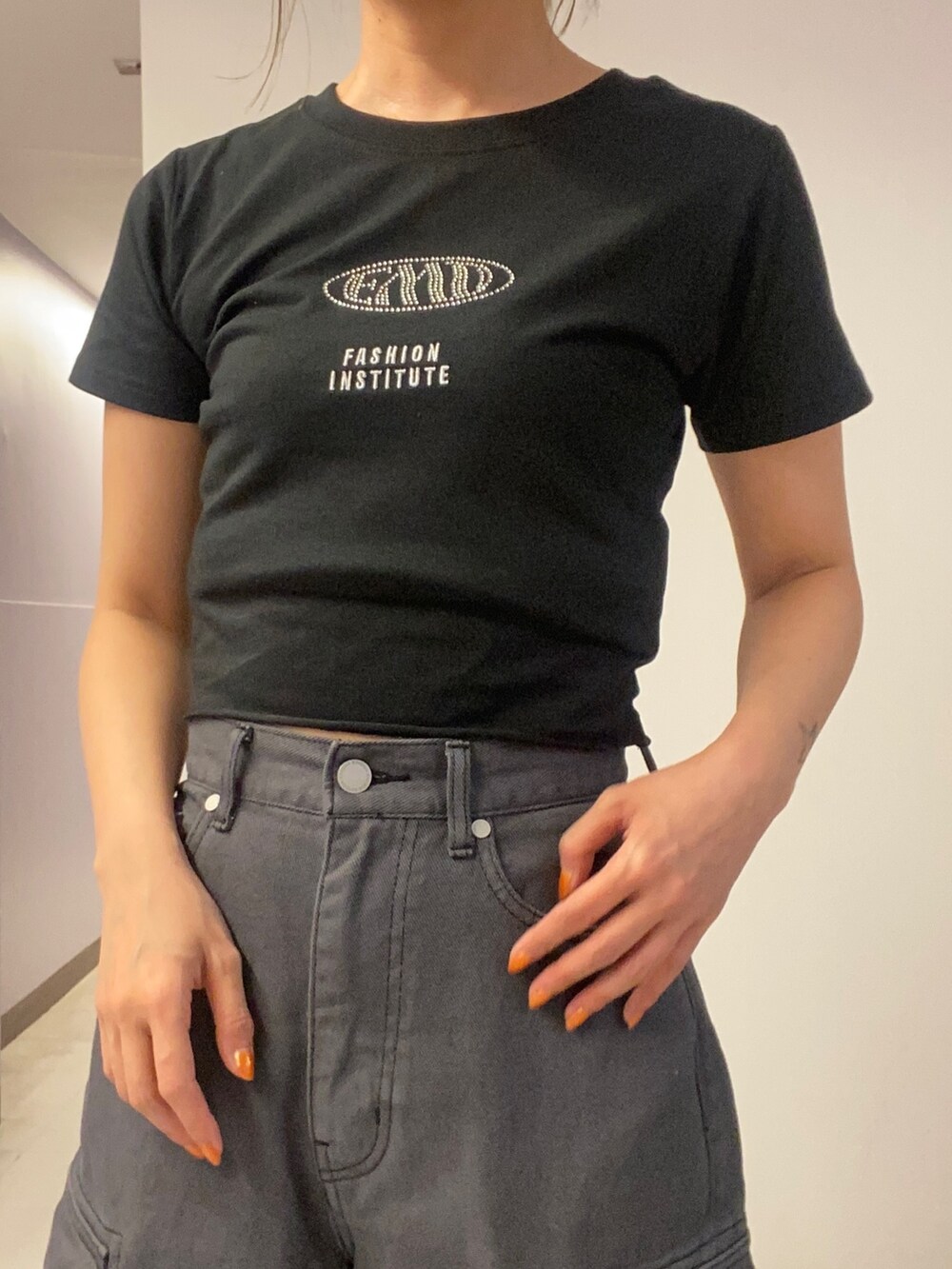 ブラック系のTシャツ/カットソー、ブラック系のデニムパンツ、ホワイト系のサンダルを着用したレディースの春コーディネートの5枚目の写真