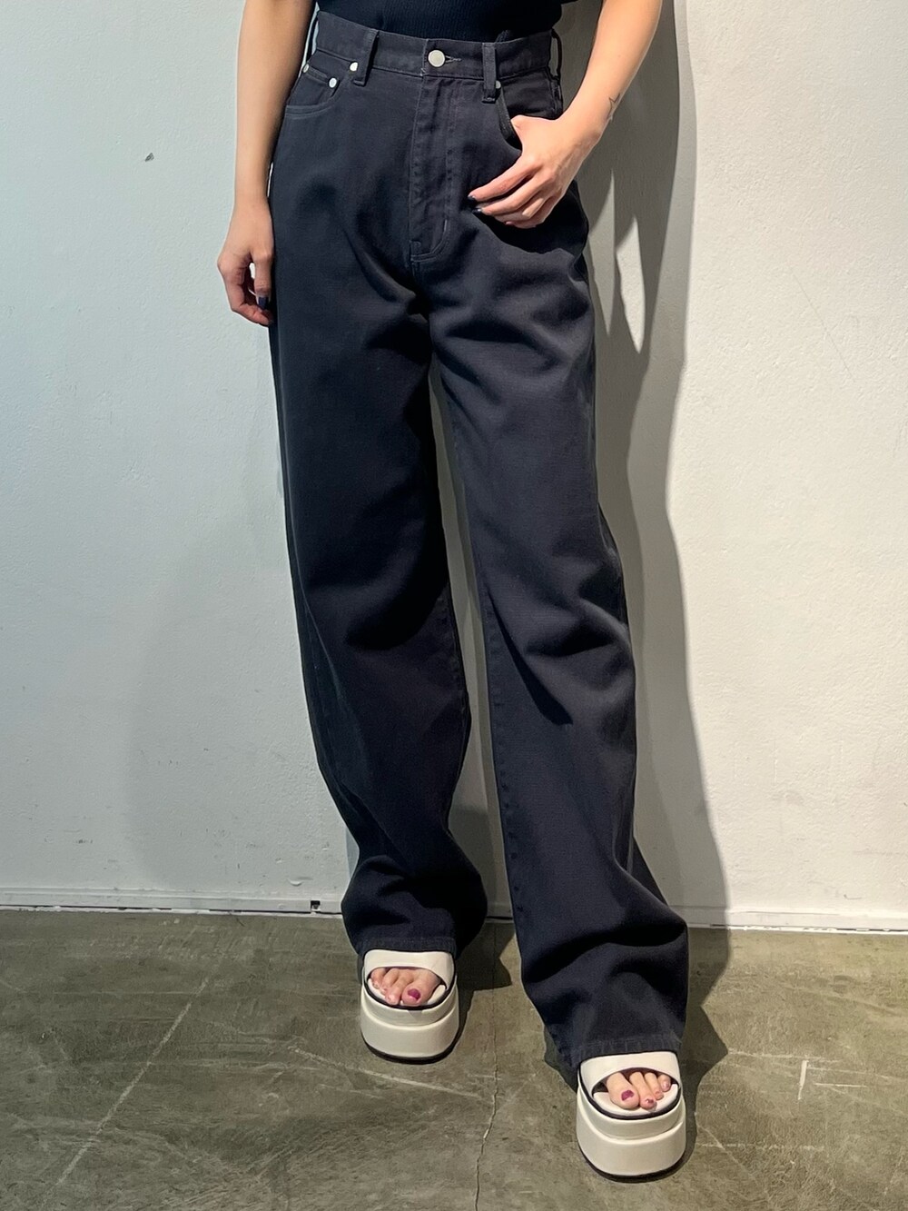 ホワイト系のTシャツ/カットソー、ブラック系のデニムパンツ、ホワイト系のサンダルを着用したレディースの春コーディネートの6枚目の写真