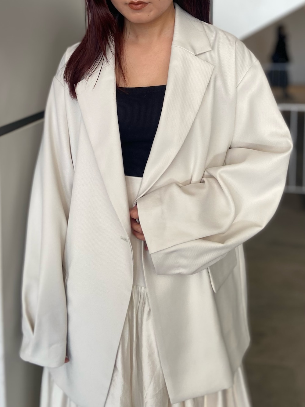 ホワイト系のテーラードジャケット、ホワイト系のスカート、ゴールド系のサンダルを着用したレディースの冬コーディネートの4枚目の写真