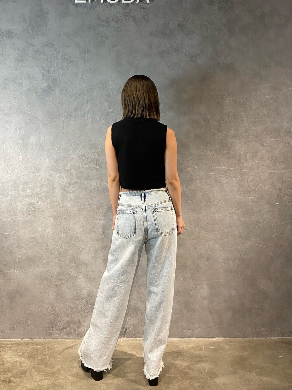 ブルー系のデニムパンツ、ブラック系のサンダルを着用したレディースの春コーディネートの4枚目の写真