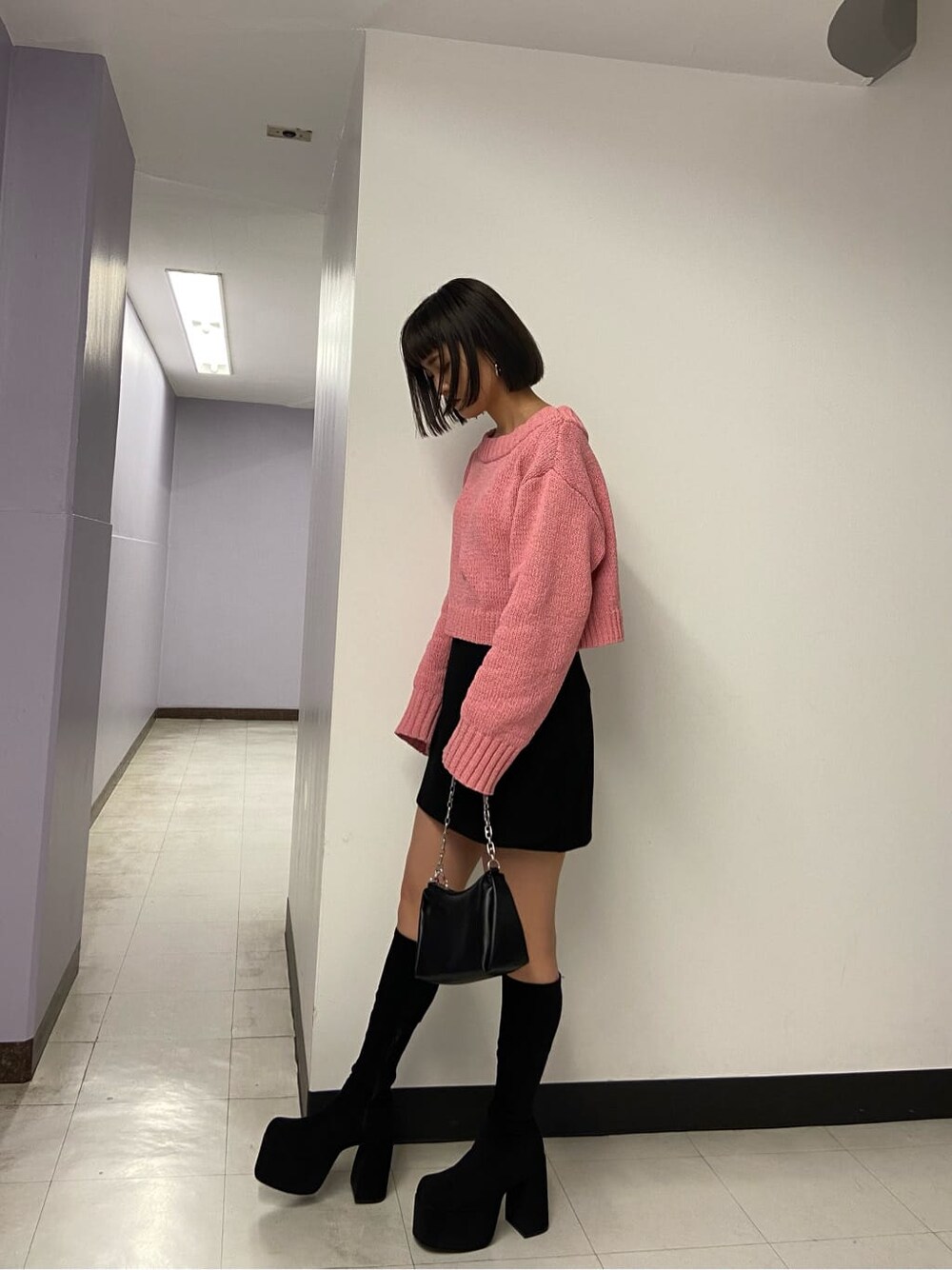 ブラック系のブーツ、ブラック系のスカート、ピンク系のニット/セーターを着用したレディースの秋コーディネートの3枚目の写真