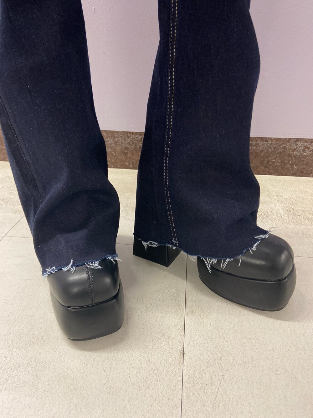 ブラック系のブーツ、ブルー系のデニムパンツ、その他のニット/セーターを着用したレディースの秋コーディネートの7枚目の写真