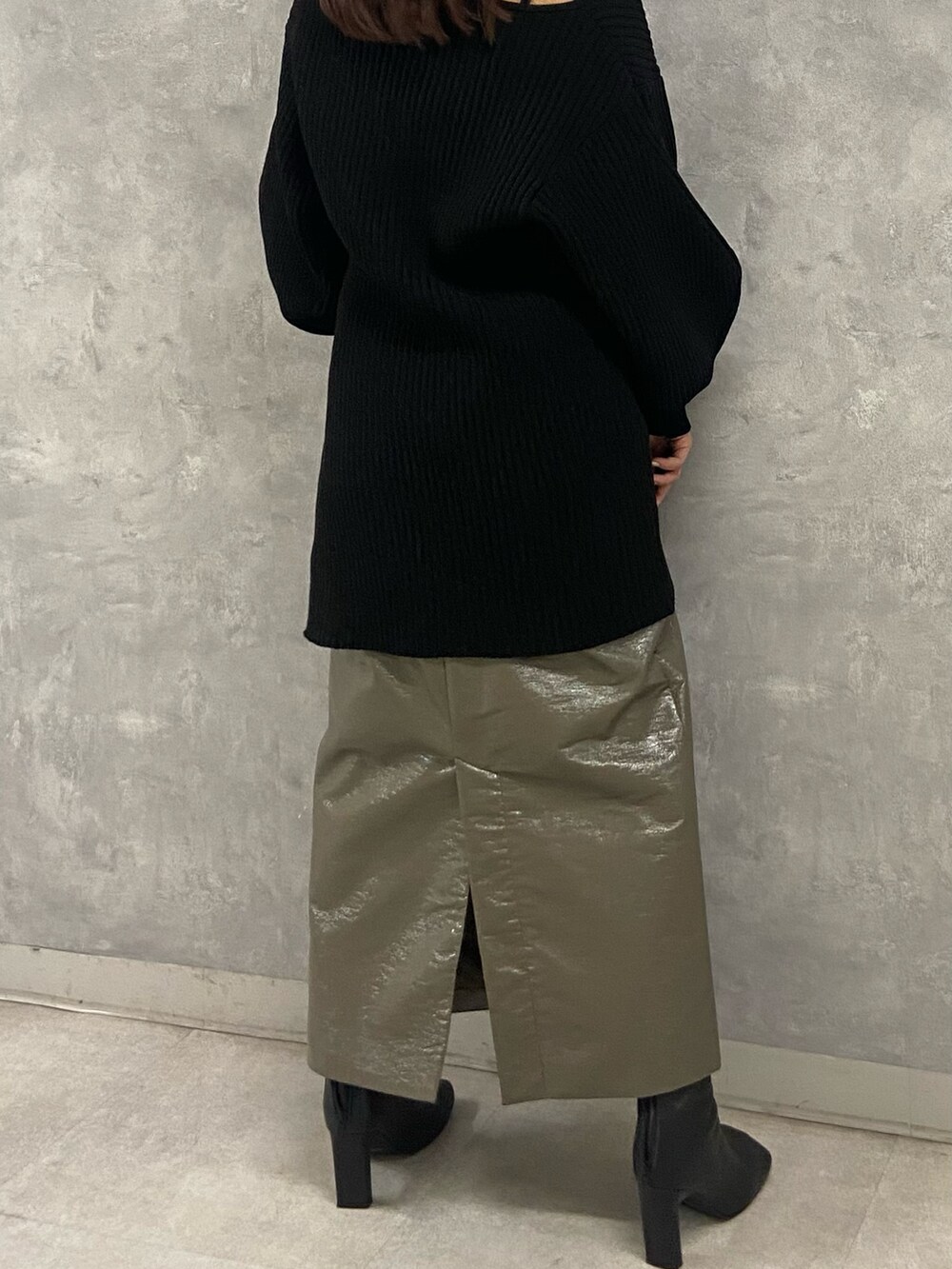 ブラック系のニット/セーター、グリーン系のスカート、ブラック系のブーツを着用したレディースの秋コーディネートの4枚目の写真