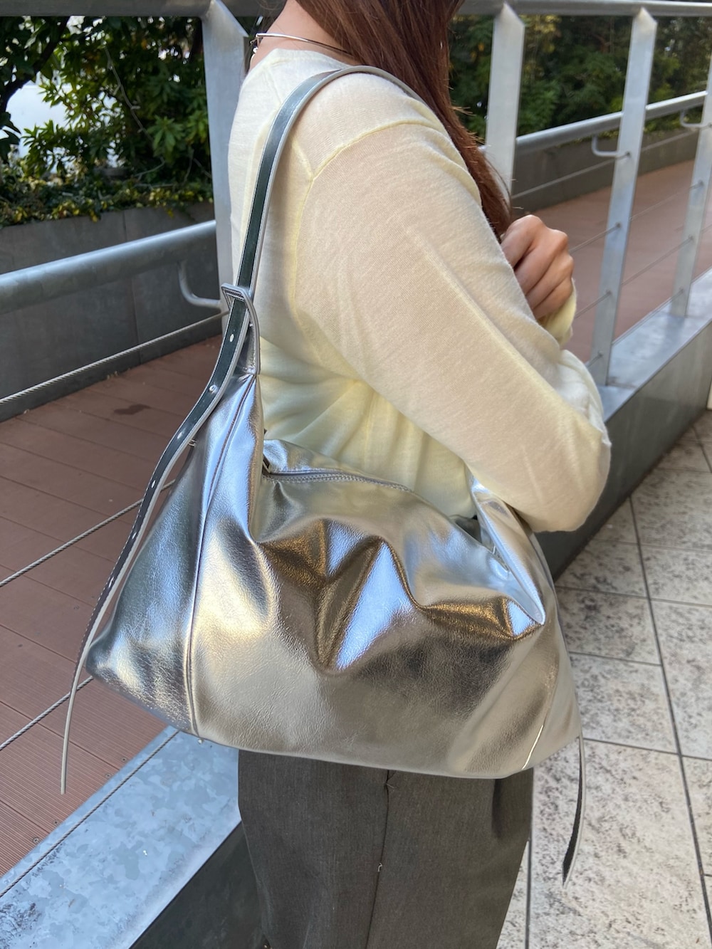 イエロー系のニット/セーター、グレー系のその他パンツ、シルバー系のローファーを着用したレディースの冬コーディネートの5枚目の写真