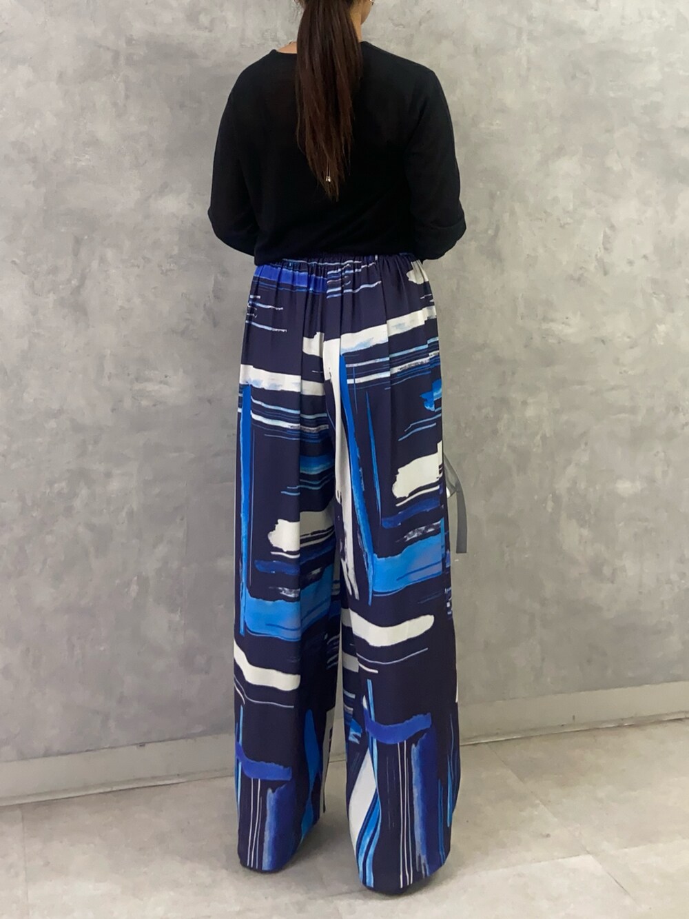 ブラック系のニット/セーター、ブルー系のその他パンツ、シルバー系のショルダーバッグを着用したレディースの秋コーディネートの4枚目の写真