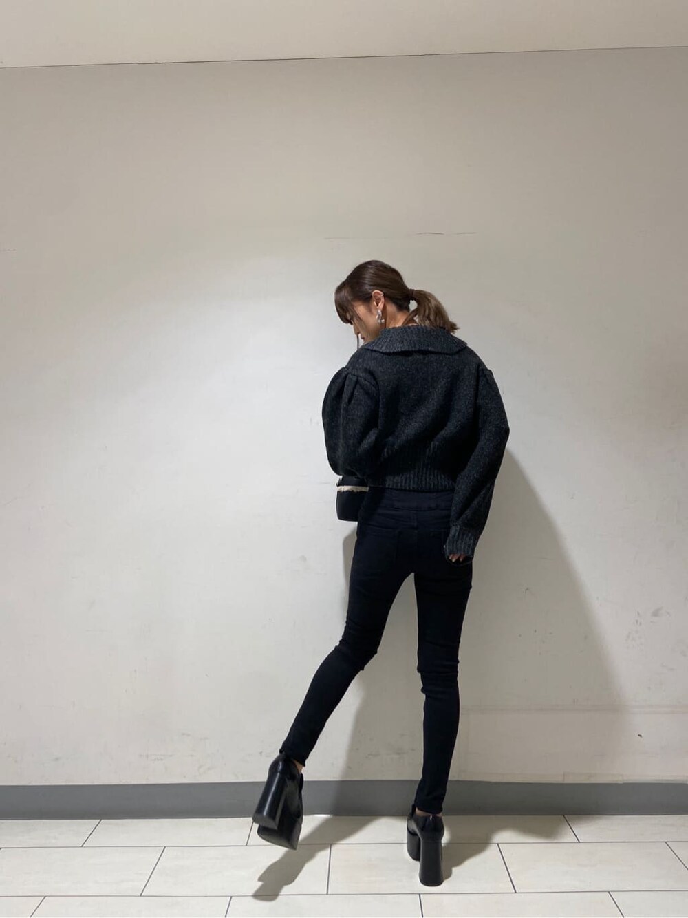 ブラック系のローファー、ブラック系のニット/セーター、ブラック系のデニムパンツを着用したレディースの冬コーディネートの2枚目の写真