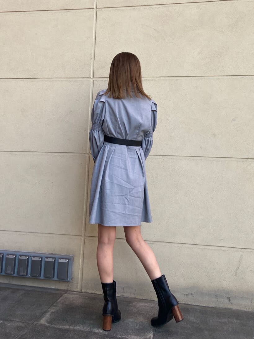 ブラック系のブーツ、グレー系のワンピース、シルバー系のピアス（両耳用）を着用したレディースの春コーディネートの4枚目の写真