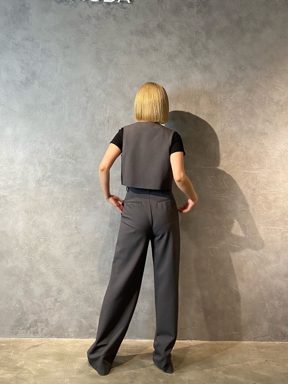 ブラック系のTシャツ/カットソー、グレー系のその他パンツ、ブラック系のパンプスを着用したレディースの冬コーディネートの3枚目の写真