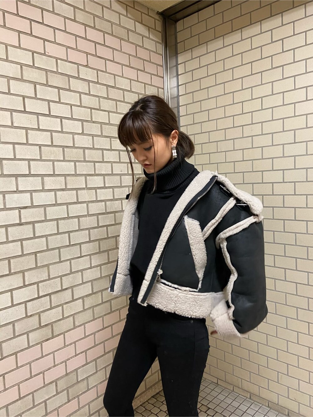 その他のムートンコート、ブラック系のブーツ、ブラック系のニット/セーターを着用したレディースの秋コーディネートの5枚目の写真