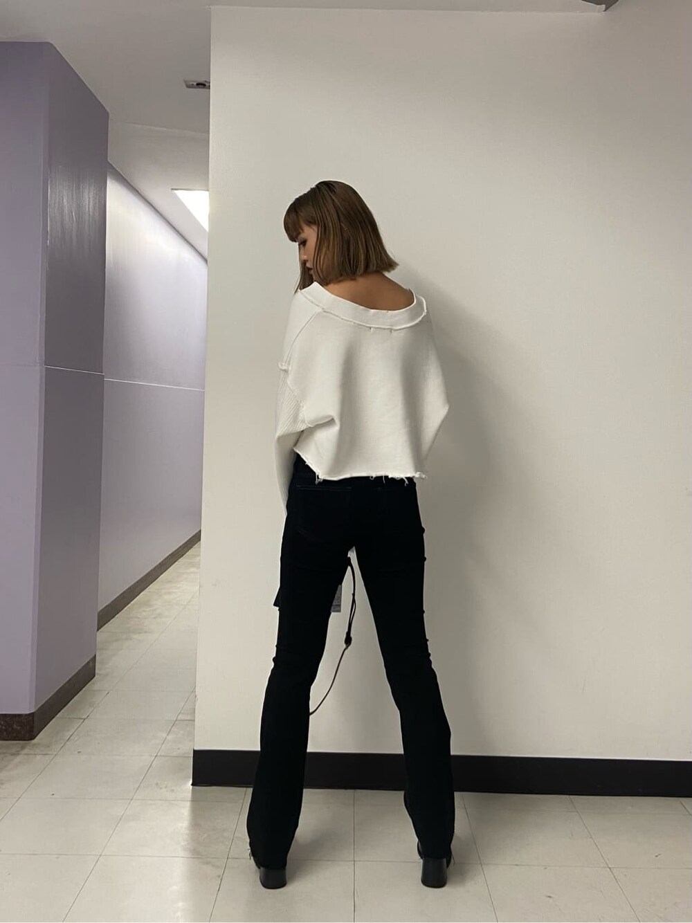 ブラック系のブーツ、ブラック系のハンドバッグ、ホワイト系のカーディガン/ボレロを着用したレディースの秋コーディネートの2枚目の写真