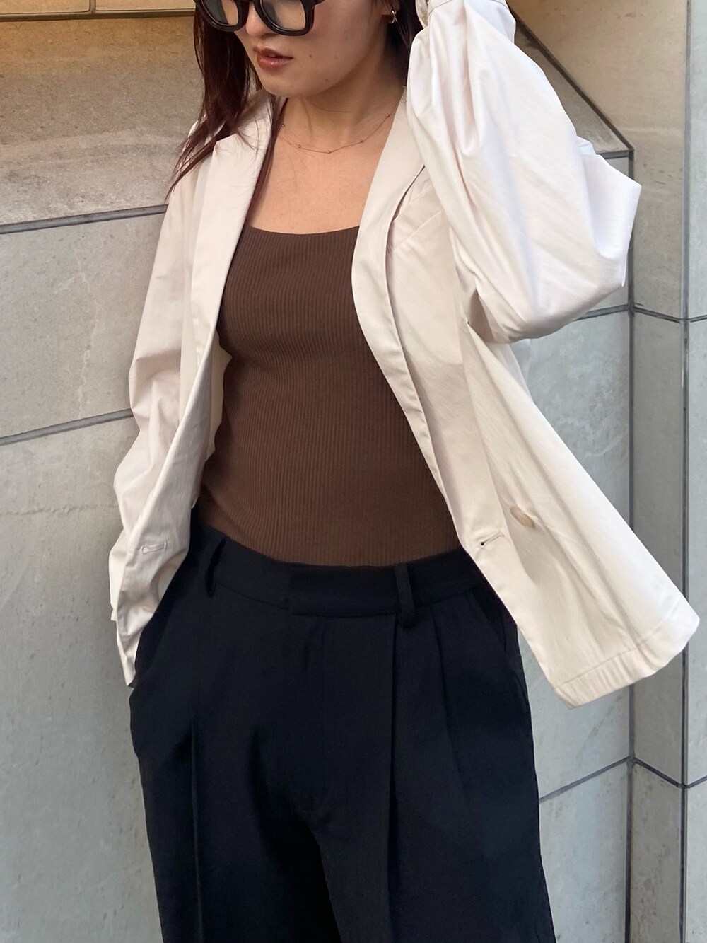 ホワイト系のテーラードジャケット、ブラック系のその他パンツ、ブラック系のサンダルを着用したレディースの春コーディネートの4枚目の写真