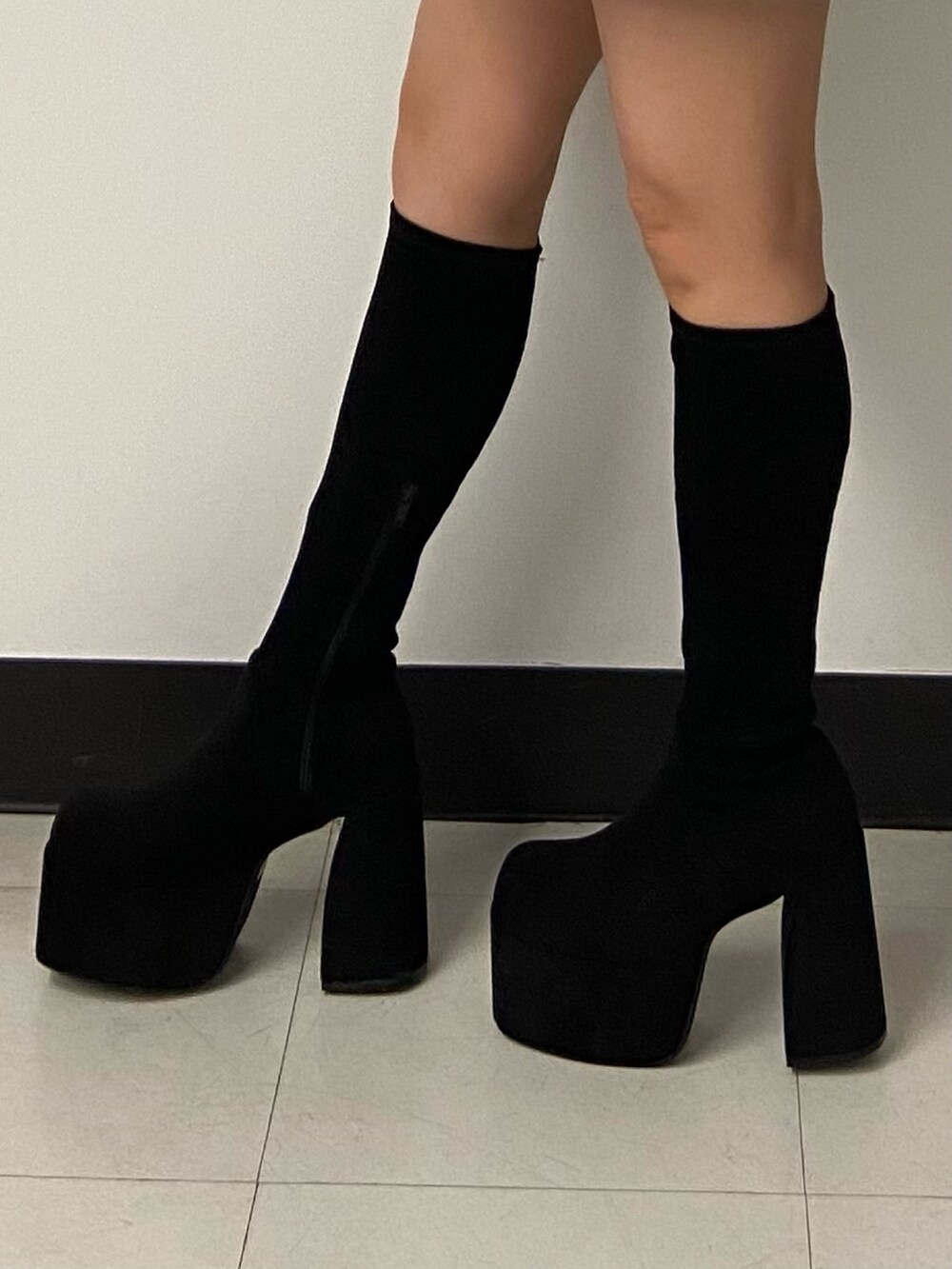 ブラック系のワンピース、ホワイト系のショルダーバッグ、ブラック系のブーツを着用したレディースの秋コーディネートの7枚目の写真