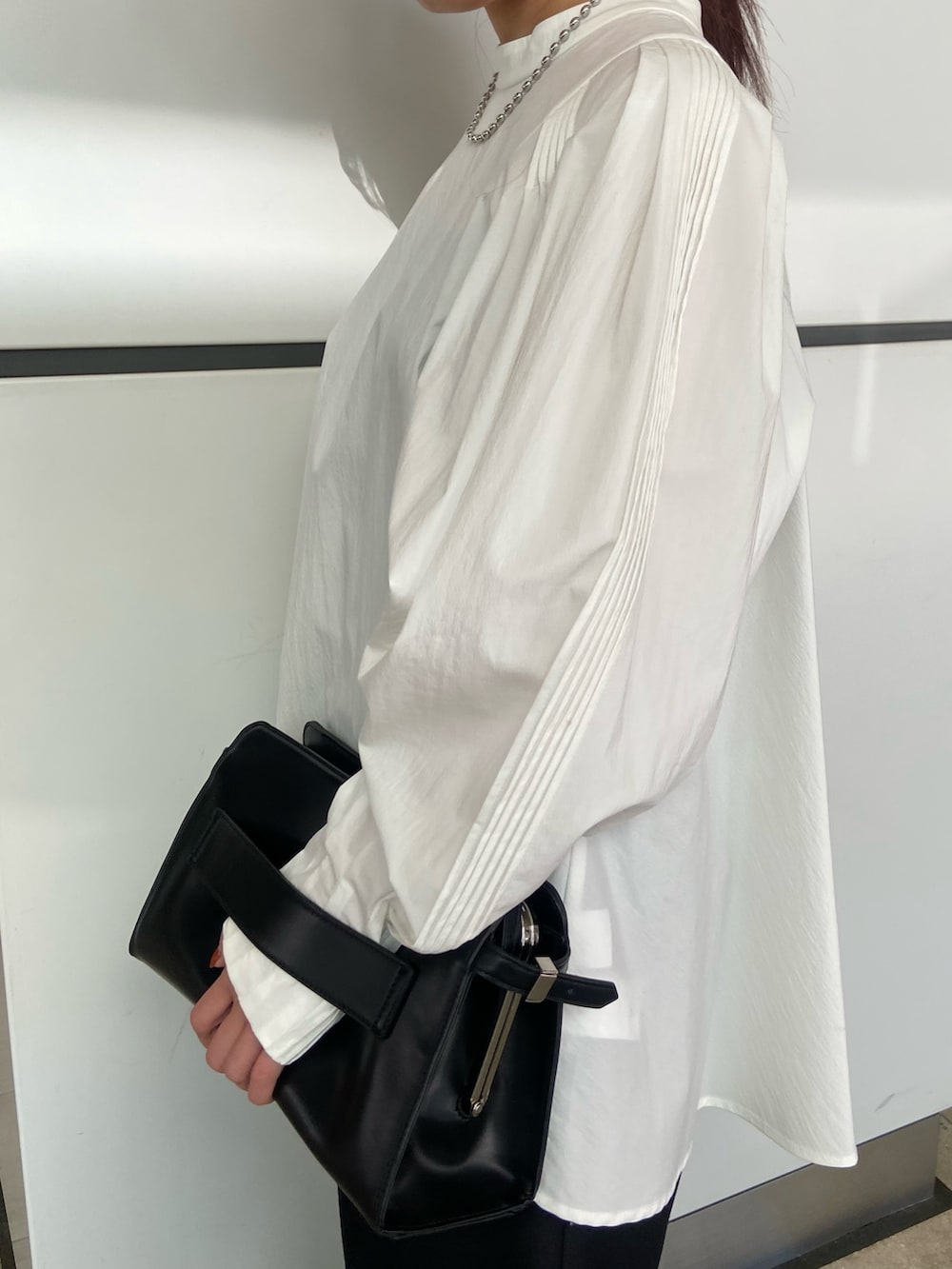 ホワイト系のシャツ/ブラウス、ブラック系のその他パンツ、ブラック系のハンドバッグを着用したレディースの冬コーディネートの5枚目の写真