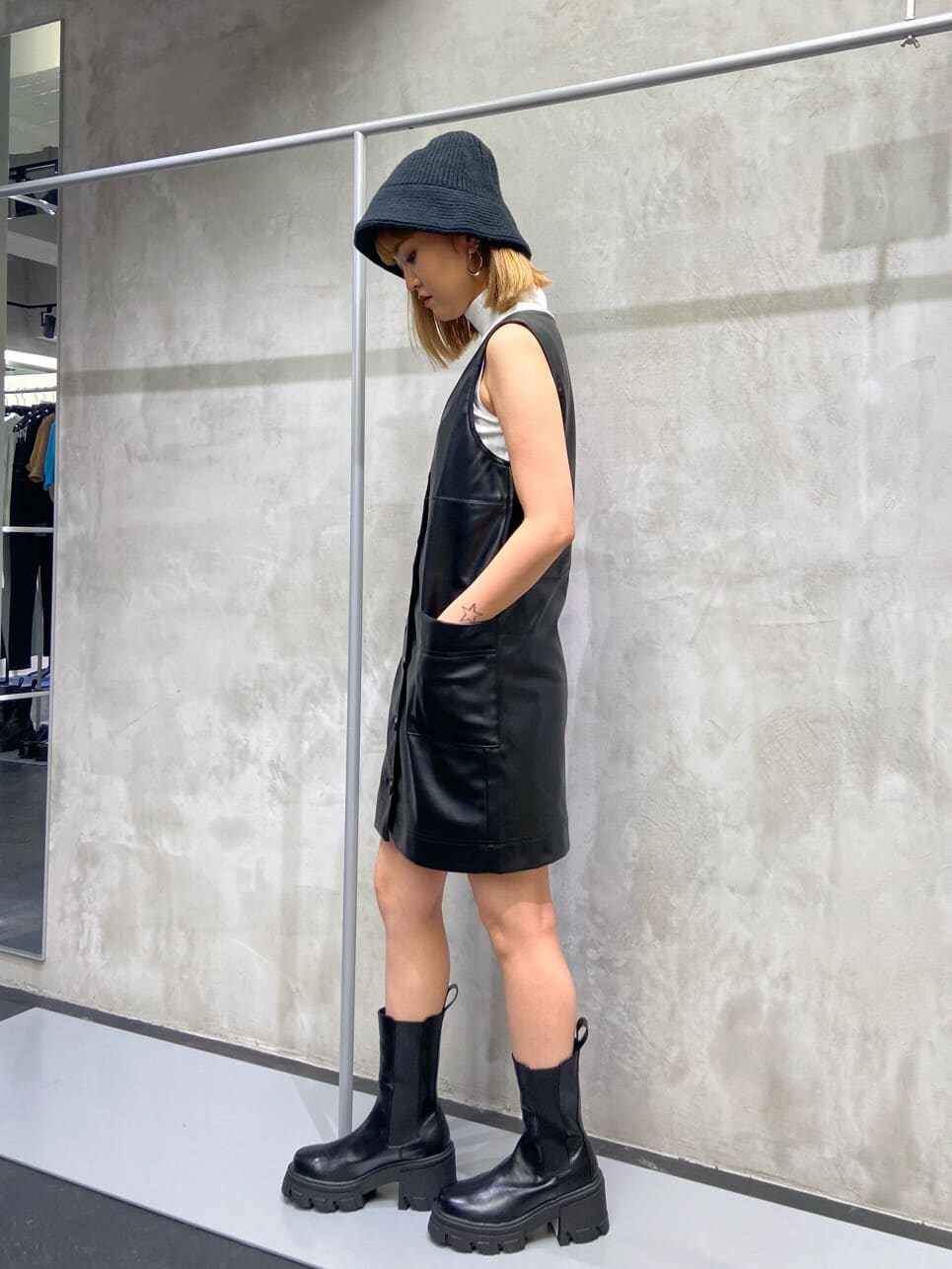 ブラック系のワンピース、ブラック系のブーツ、ホワイト系のTシャツ/カットソーを着用したレディースの夏コーディネートの3枚目の写真