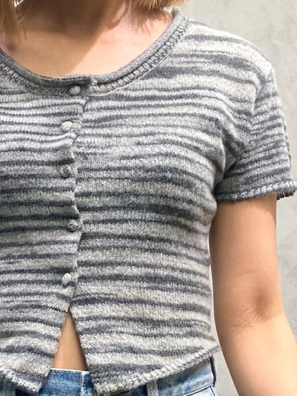 ブルー系のデニムパンツ、ブラック系のニット/セーター、ブラック系のハンチング/ベレー帽を着用したレディースの夏コーディネートの5枚目の写真