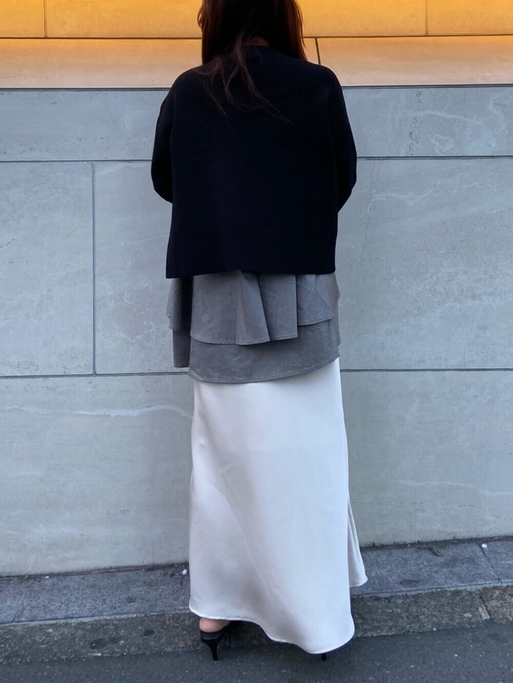 ブラック系のサンダル、ブラック系のニット/セーター、ホワイト系のスカートを着用したレディースの秋コーディネートの3枚目の写真