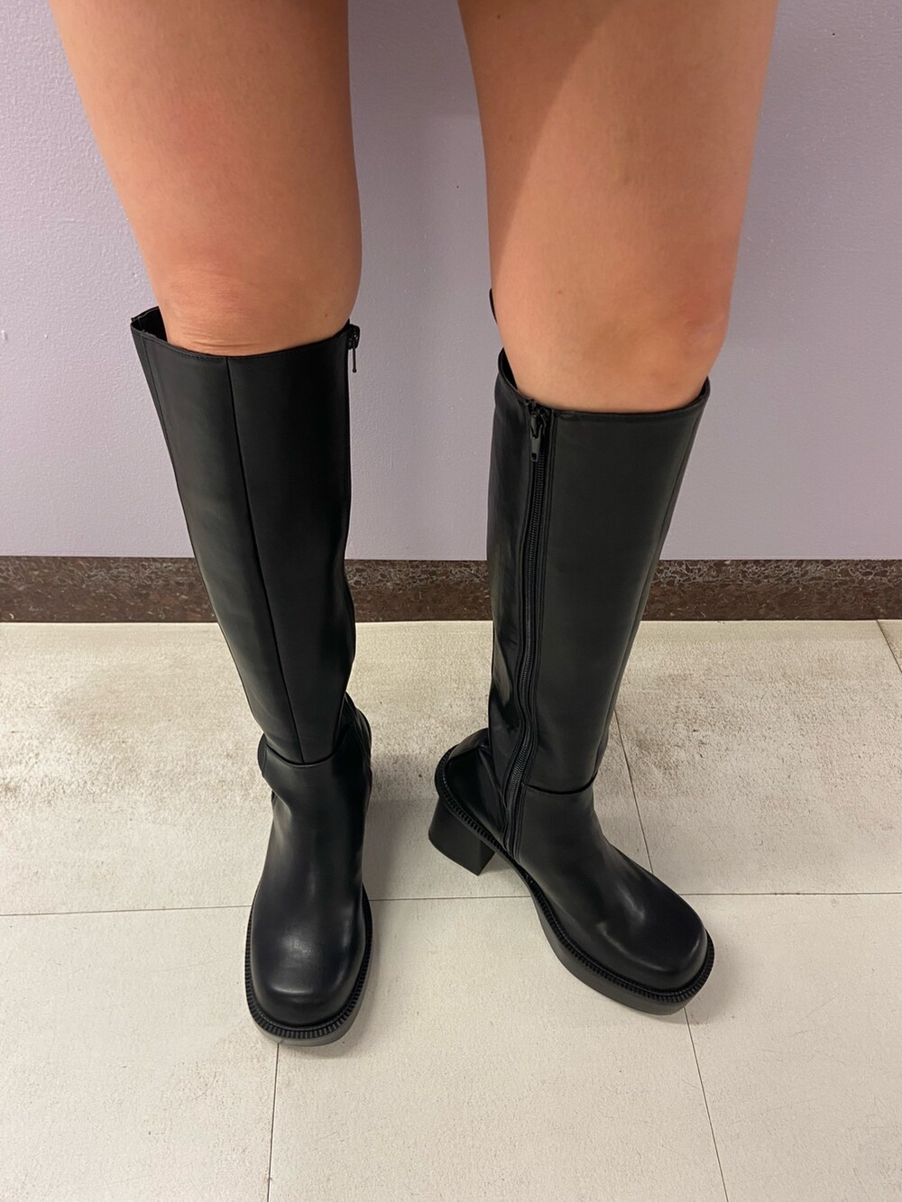 ブラック系のニット/セーター、ベージュ系のスカート、ブラック系のブーツを着用したレディースの秋コーディネートの7枚目の写真