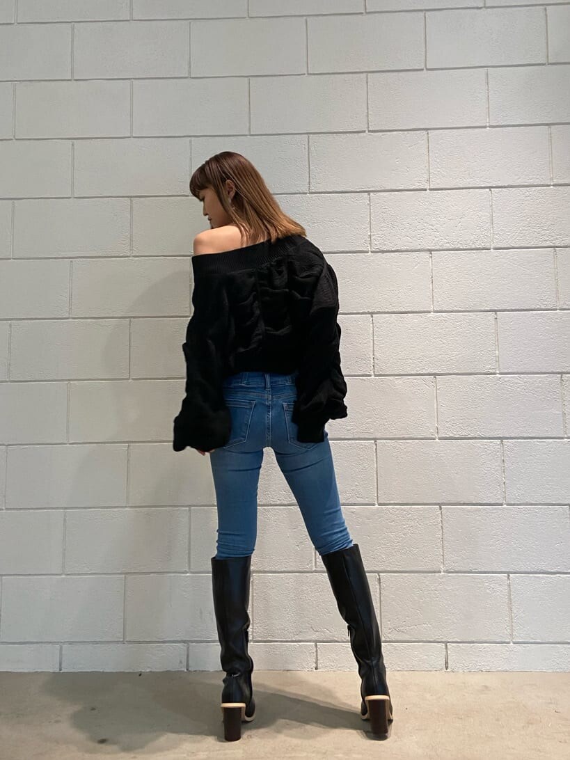 ブルー系のデニムパンツ、ブラック系のブーツ、ブラック系のニット/セーターを着用したレディースの冬コーディネートの6枚目の写真