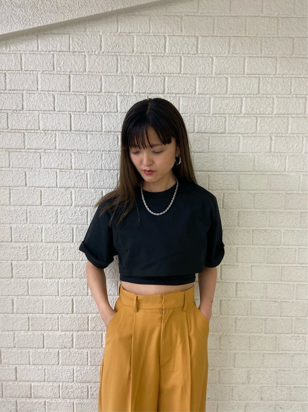 ブラック系のサンダル、オレンジ系のその他パンツ、ブラック系のTシャツ/カットソーを着用したレディースの春コーディネートの4枚目の写真