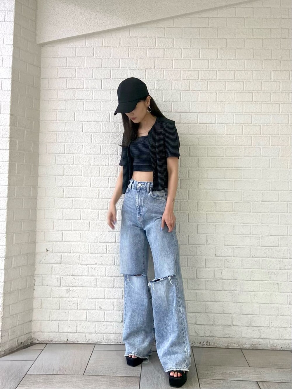 ブラック系のサンダル、ブルー系のデニムパンツ、その他のアンサンブルを着用したレディースの夏コーディネートの2枚目の写真