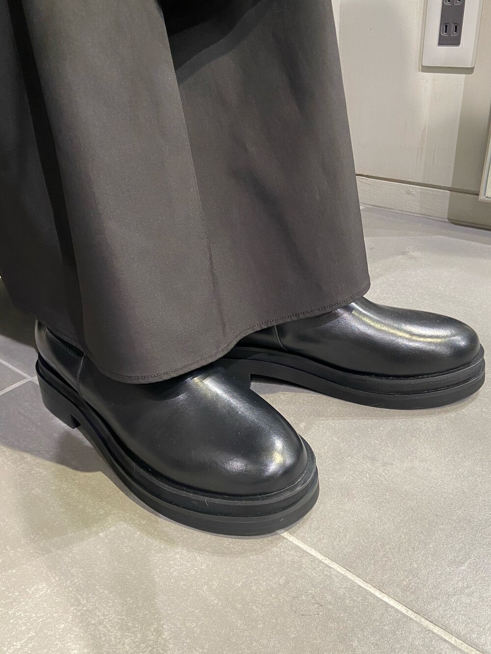 ベージュ系のカーディガン/ボレロ、ブラック系のスカート、ブラック系のブーツを着用したレディースの秋コーディネートの5枚目の写真