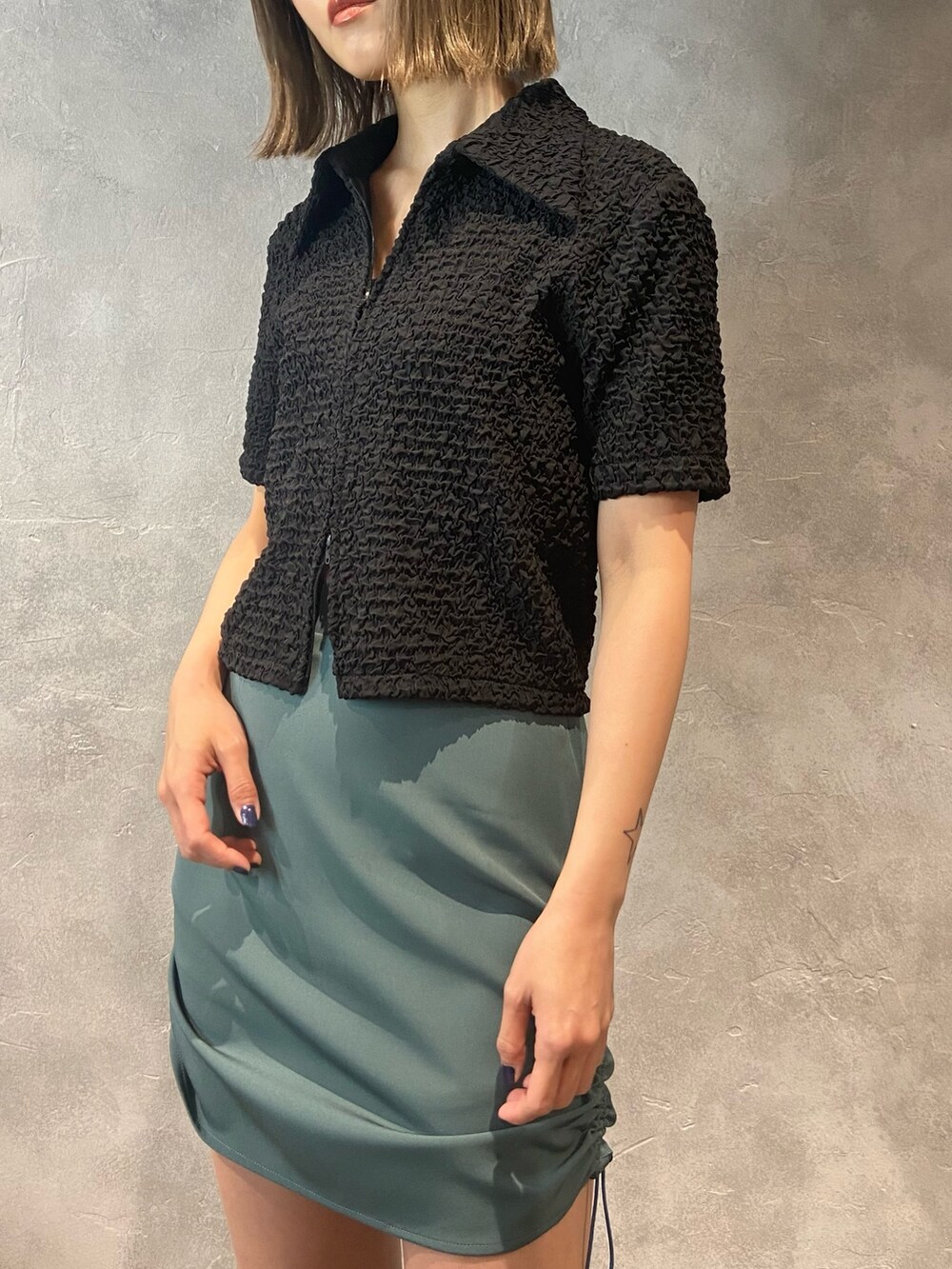 ブラック系のシャツ/ブラウス、グリーン系のスカート、ブラック系のサンダルを着用したレディースの春コーディネートの5枚目の写真