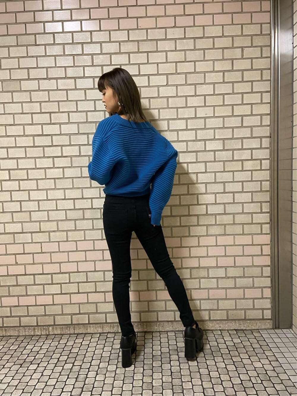 ブラック系のローファー、ブラック系のデニムパンツ、ブルー系のニット/セーターを着用したレディースの冬コーディネートの3枚目の写真