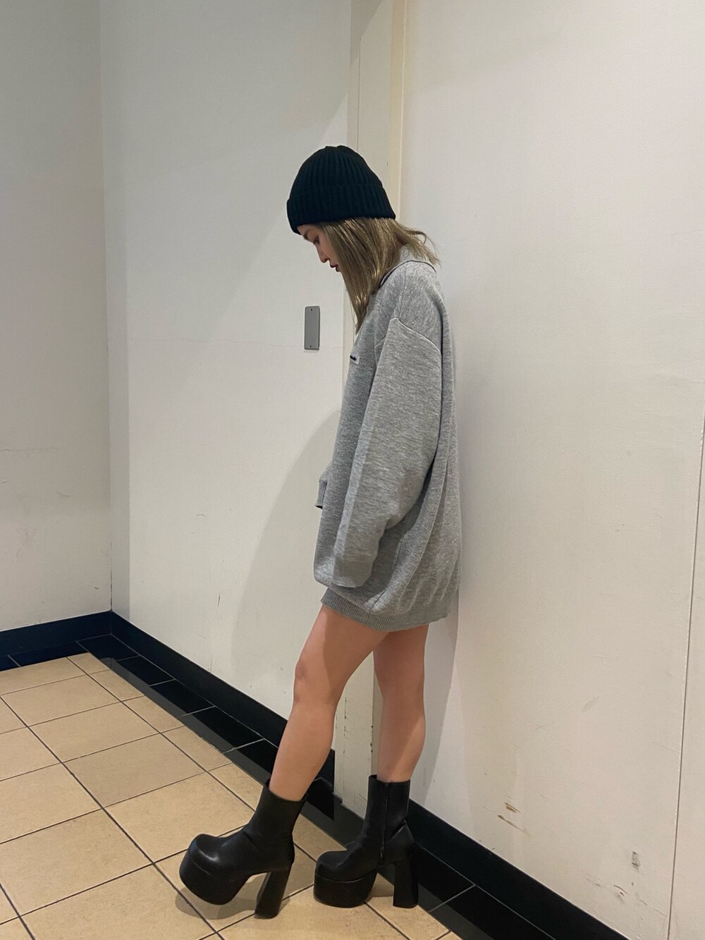 グレー系のワンピース、ブラック系のブーツ、ブラック系のニットキャップ/ビーニーを着用したレディースの秋コーディネートの3枚目の写真